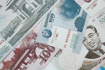 North Korean won money bills in big amount lies on white color table close up