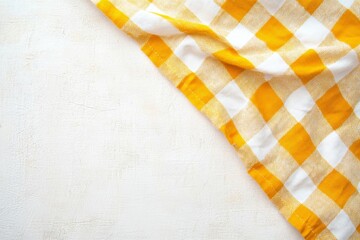 Yellow and white checkered cloth napkin on a light beige surface