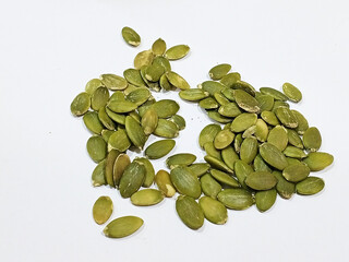 Close-up of raw pumpkin seeds on a white background, healthy organic snack rich in magnesium, fiber, plant protein, keto-friendly, perfect for salads, baking, and nutritious diets.