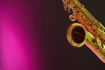Golden saxophone on color background, closeup. Space for text