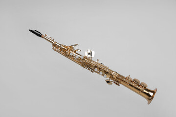 Golden soprano saxophone on light grey background