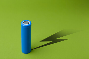 Alkaline battery with shadow in shape of lightning on green background