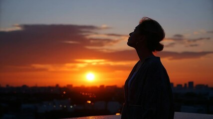 A woman in silhouette against the sunrise promoting community welfare