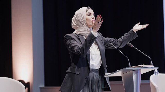 Confident Muslim woman Conference Speaker Expressing Ideas on Stage  