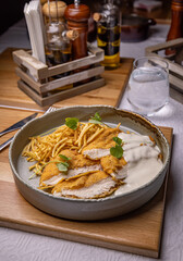 Breaded chicken breast with white sauce