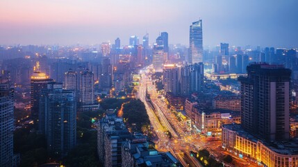 Obraz premium Aerial view of a bustling metropolis at night with illuminated high-rises and busy traffic below