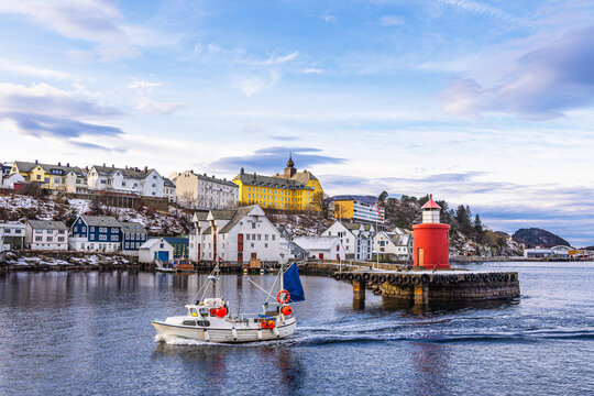 Blick auf die Stadt &Aring;lesund mit Molenturm und Fischerboot in Norwegen