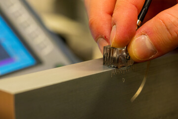 Ultrasonic Testing Calibration Process on Reference Block in NDT Lab. Close-up of technician adjusting UT transducer settings for precision inspection