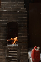 Burning firewood in brick oven with red watering can in hong kong