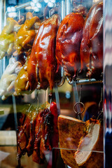 Roasted ducks, chickens and pork hanging in a hong kong food stall