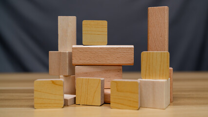 Obraz premium A creative arrangement of wooden blocks of various shapes and sizes, showcasing natural wood textures and colors. Perfect for educational, architectural, or design concepts.