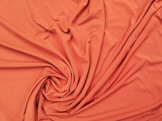 Orange abstract background. Beautiful wavy soft folds on the surface of the fabric texture. Teal elegant background with copy space for design. Web banner.