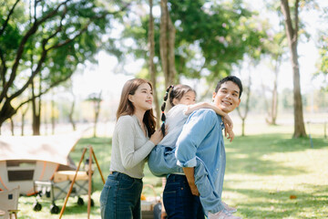 Happy parents and daughter Bakery and Bread Fruit enjoy  in a sunny garden. A joyful summer picnic...