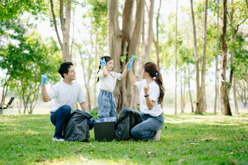 Naklejka premium Asian parents and child collect trash in the forest, promoting recycling, unity, and ecology. A heartwarming scene of love, care, teamwork