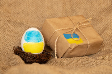 Easter egg with Ukrainian flag and a parcel with a flag, support for Ukraine during holidays, Easter