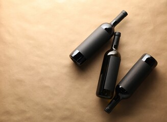Bottles of wine on parchment paper, flat lay. Space for text