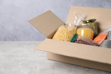 Different food products in box on gray textured table