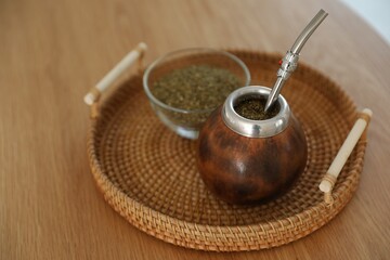 Traditional yerba mate tea on wooden table, closeup