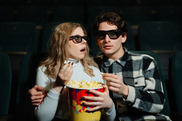 Couple enjoys movie night with popcorn and 3D glasses at the cinema