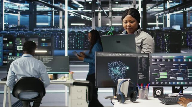 Cheerful data center employee using node tree software to analyze datasets. Upbeat server facility engineer using visual programming to improve infrastructure performance, camera A