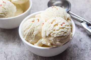 vanilla scoop ice cream in a bowl with colorful sprinkles