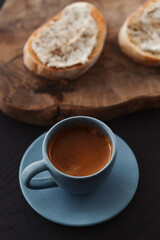 Espresso in blue cup with sandwiches with cream cheese on background