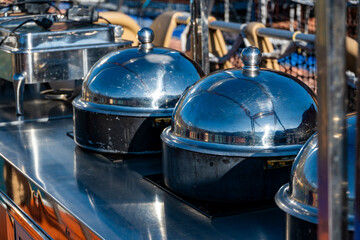 Steel food warming domes are ready for use in the kitchen. Their design ensures durability and effectiveness in maintaining food temperature.