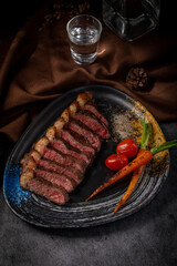 A plate of meat and vegetables with a glass of water on the table