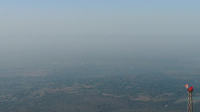 Aerial shot from Pavagadh hill in Gujarat, India, showing rural expanse, temple flag and clear skies. Ideal for heritage, spiritual, travel and cinematic use in 4K quality.