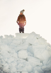 The boy climbed a mountain of snow blocks
