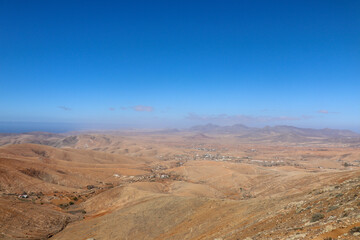 Expansive desert plain meeting clear blue sky