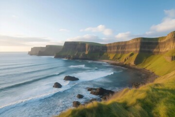 Obraz premium Scenic view of waves crashing against the Cliffs of Moher at sunset, a popular tourist destination located in County Clare, Ireland