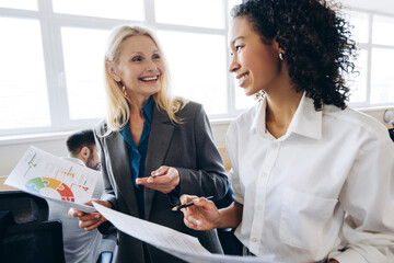 Businesswomen discussing financial charts and reports in office
