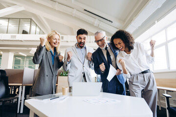 Fototapeta premium Excited business team celebrating success in modern office
