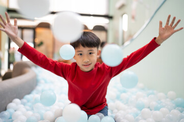 Boy playing with balls in indoor playground