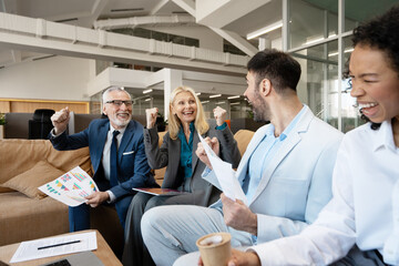 Excited business team celebrating successful results in modern office