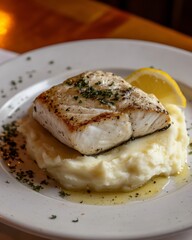 a grilled seabass fillet resting on mash