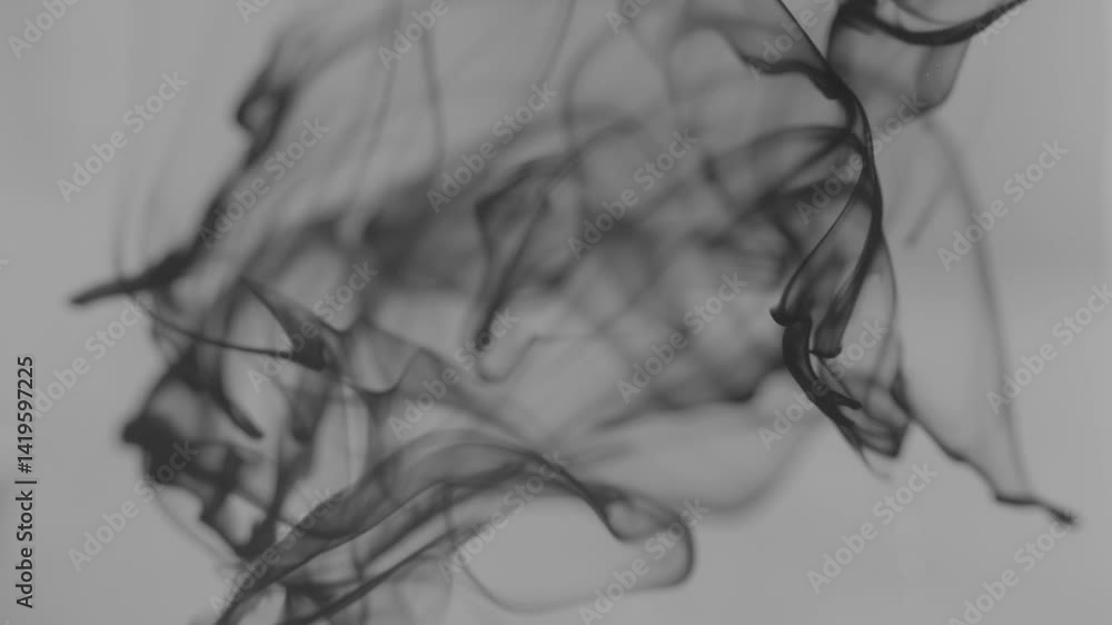 Poster black ink swirling in water creates mesmerizing abstract patterns in studio setting