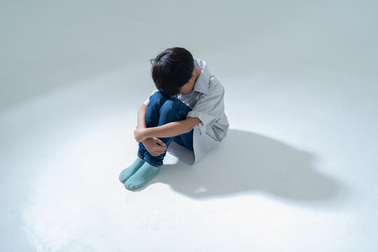Sad boy sitting alone with head down