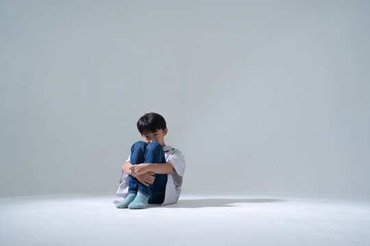 Sad boy sitting alone with head down