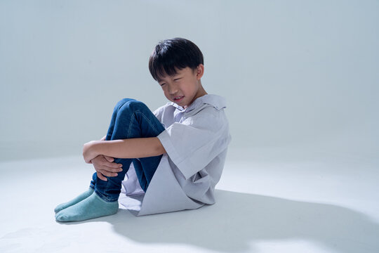 Sad boy sitting alone with head down