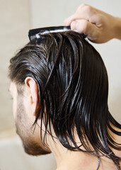 Naklejka premium a brunette with long hair applies hair balm, caring for them