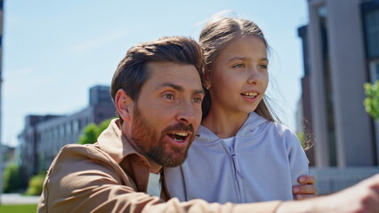 Father daughter looking distance at greenery neighbourhood closeup. Man pointing