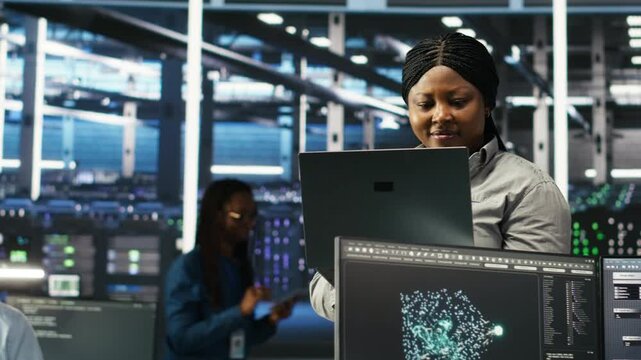 Data center computer scientists use node tree programming to identify equipment performance issues. Server farm employees review data analysis graphs to minimize infrastructure failures, camera B