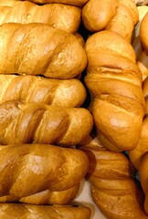 golden brown bread rolls are carefully arranged to showcase their texture and appealing shape. aroma freshly baked goods fills the air in bakery. close up.