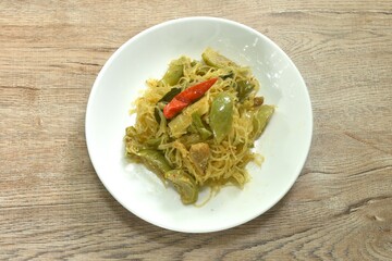 stir fried spicy mixed glass noodles with vegetables and pork belly in Curry powder Thai northern style on plate
