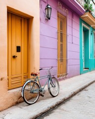 Fototapeta premium Cuban alley with pastel buildings, vintage bicycle parked near door, warm travel mood and cultural texture