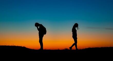 Silhouette of a couple distancing on a hill against a vibrant sunset sky