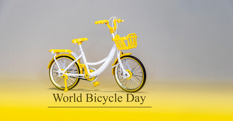 World bicycle day text Toy bicycle white, violet, grey background.   