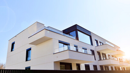 Modern architecture of urban residential apartment buildings on a sunny day. Low-rise apartment buildings with large windows and extensive terraces. White facade of a modern apartment building.